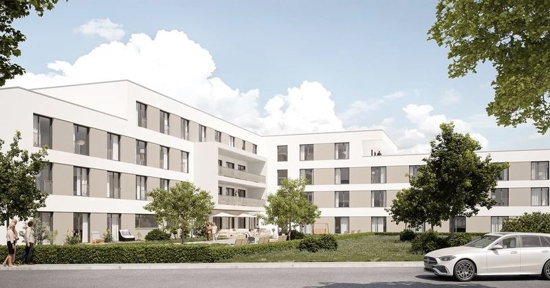 Visualisierung einer modernen Pflegeimmobilie mit heller Fassade, Grünflächen und parkenden Fahrzeugen