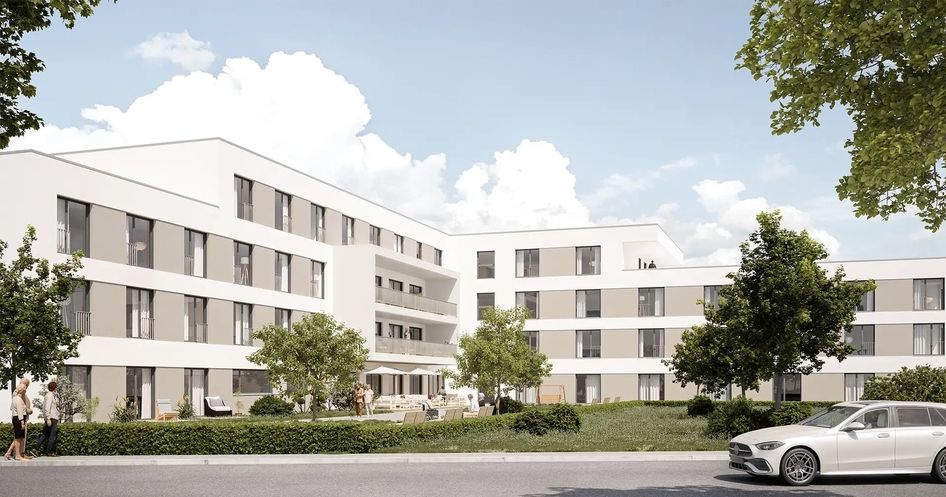 Visualisierung einer modernen Pflegeimmobilie mit heller Fassade, Grünflächen und parkenden Fahrzeugen