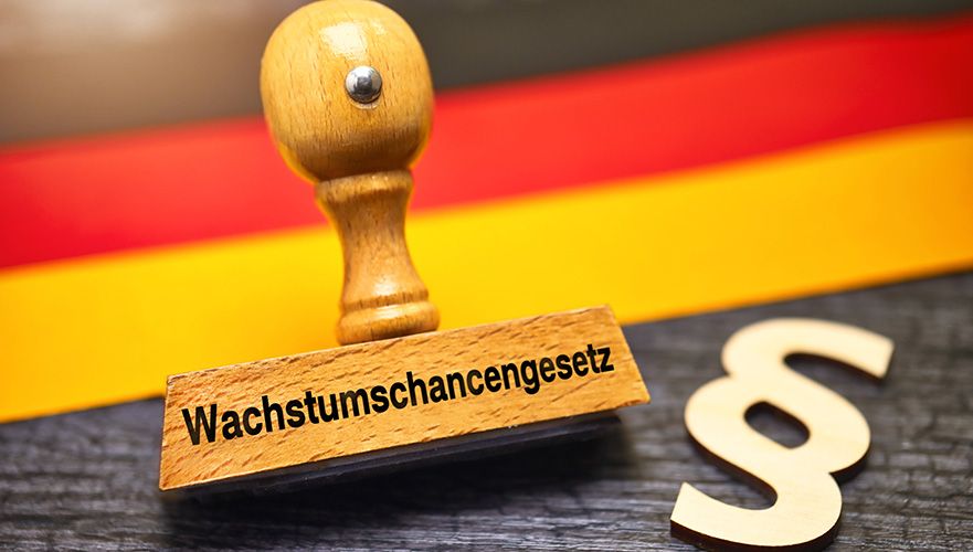 Symbolbild zum Wachstumschancengesetz mit Stempel, Paragrafenzeichen und Deutschlandfarben im Hintergrund
